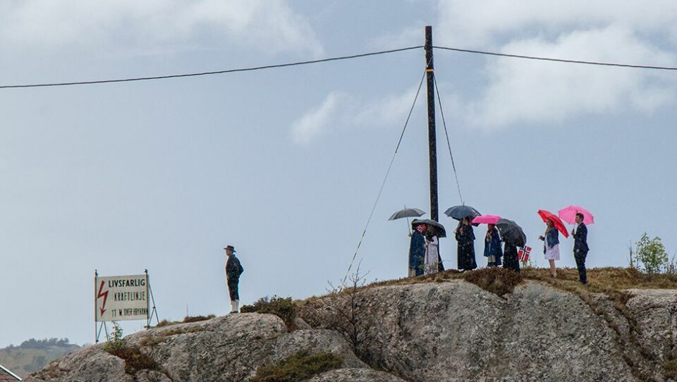 I Åshavn, på vestsiden av Flekkerøy, strømmet folket til denne formiddagen.
N247s reporter på stedet sier at stemningen var magisk og forventningsfull, akkurat som i fjor.
Musikantene fra Flekkerøy skolekorps kom pent og pyntelig i sine velkjente uniformer, og ombord i fiskebåten Malena og i vareruta Birgit loddet de stemningen med sine musikalske innslag. Han er noe usikker på om det var like mange båter som stilte i år som i fjor, men mange var det også i år.
- Et nytt vakkert og flott båttog ble det. Båter i mange forskjellige varianter som var pyntet til fest minnet veldig mye om fjoråret. Det var bare godværet som manglet, lyder rapporten fra Flekkerøy 17. mai.
Film og flere bilder fra årets båtkortesje kommer på N247 senere.
Litt regn la liten demper på stemningen blant tilskuerne som ventet på at båtkortesjen skulle passere. (Foto: Jon Aamodt).
Bildet over og bildet under: Båtkortesjen i ferd med å sette seg i bevegelse på vei vestover fra Langenesbrygga. (Foto: Jon Aamodt)