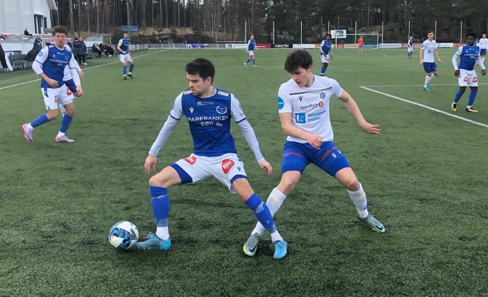 Fløys Anders Hella (i blått) i kamp med en Notodden-forsvarer under treningskampen på Flekkerøy lørdag ettermiddag.