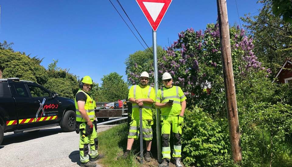 Adri Gradinariu t.v., Stian Aukland og Jan Helge Pettersen i bedriften Express har hatt jobben med å fjerne de gamle og sette opp de nye skiltene langs fylkesveien på Flekkerøy.