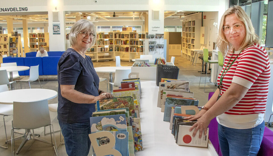 Bibliotekar Margrete Loland gjør klar til det store bruktboksalget, mens bibliotekkunde Dorrit Svenning tar en kikk på utvalget.