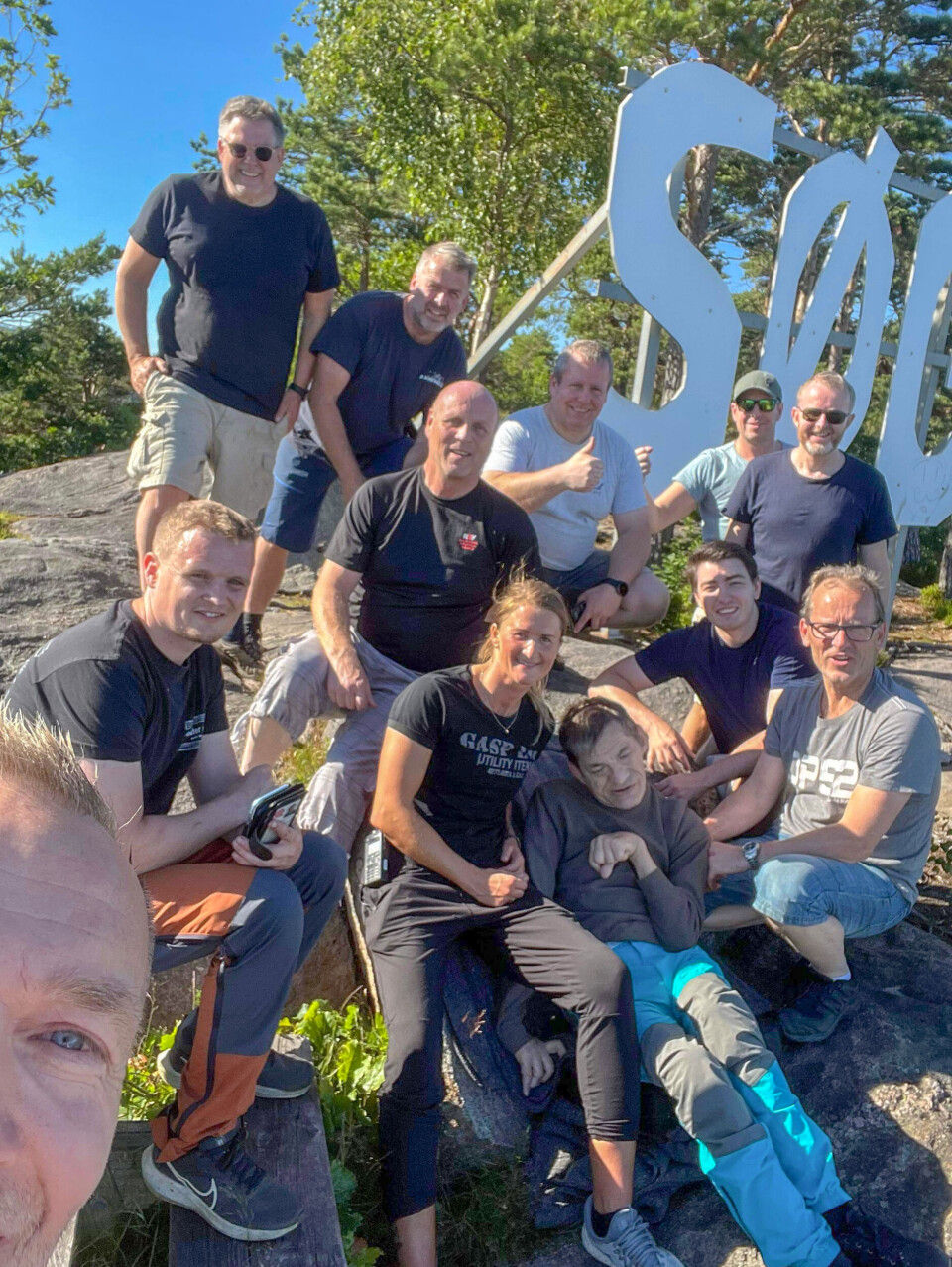 Bjarne Andersen med sine frivillige hjelpere ved Søgne-skiltet.