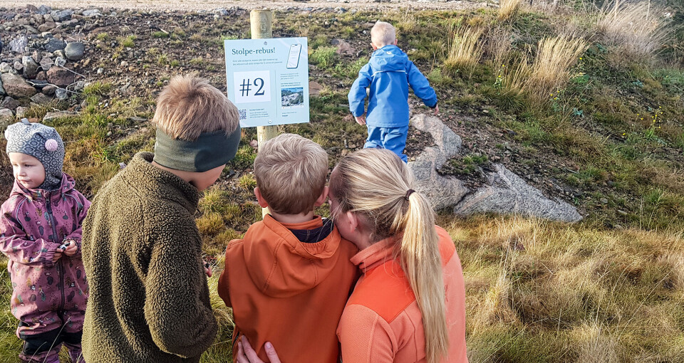 Tora Emilia, Walter, Brede og Aasmund har kommet seg til andre stolpe og får hjelp av Mari Aamodt til skanning av QR-kode og veien videre til neste stolpe.