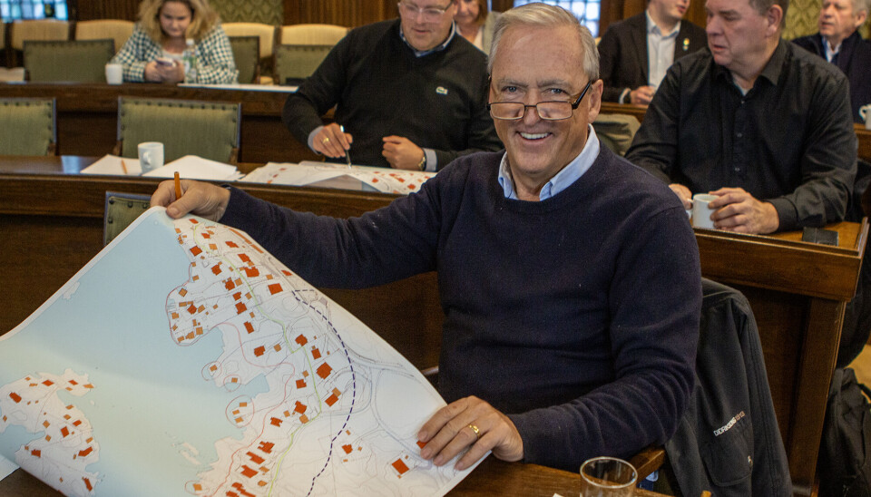 Lederen for areal- og miljøutvalget i bystyret, Odd Nordmo (H), presenterer arbeidsgruppens forslag til byggegrense. I forslaget vil bygg plassert bak den inntegnede røde linjen få en forenklet søknadsprosess, mens eiendommer nærmest sjøen (markert med sirkel) vil bli underlagt et forbud mot tiltak. Arbeidsgruppen som utarbeidet forslaget, inkluderte politikere fra Høyre, FrP og KrF. I Bakgrunnen sitter Svein-Harald Mosvold Knutsen og Roy Fardal fra Pensjonistpartiet.