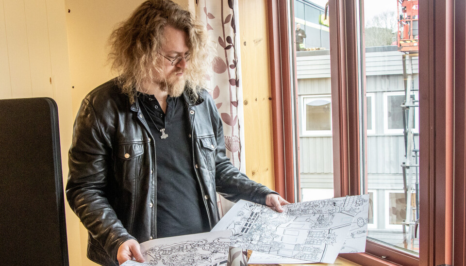Mathias Dønnestad med originaltegningene til sitt seneste motiv fra Ny-Hellsesund.
